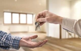 Un agent immobilier transmet des clés de maison à un acheteur