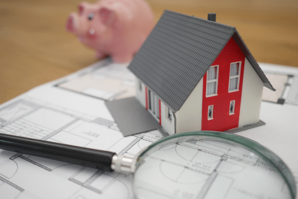 investissement locatif : image avec maison, plan, loupe et tirelire